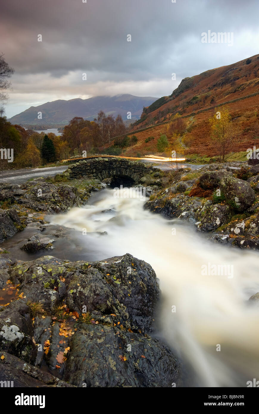 Car Lights Over Ashness Bridge With Skiddaw In the Distance Stock Photo