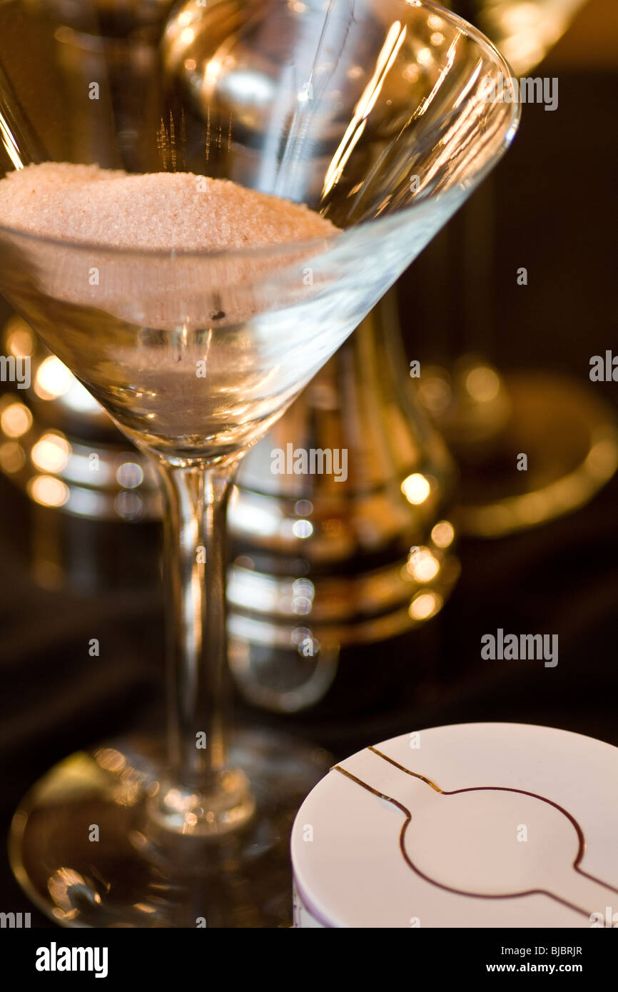 Salt and pepper displayed in open glasses, with metal pepper mills present and a round white box in the lower right corner. Stock Photo