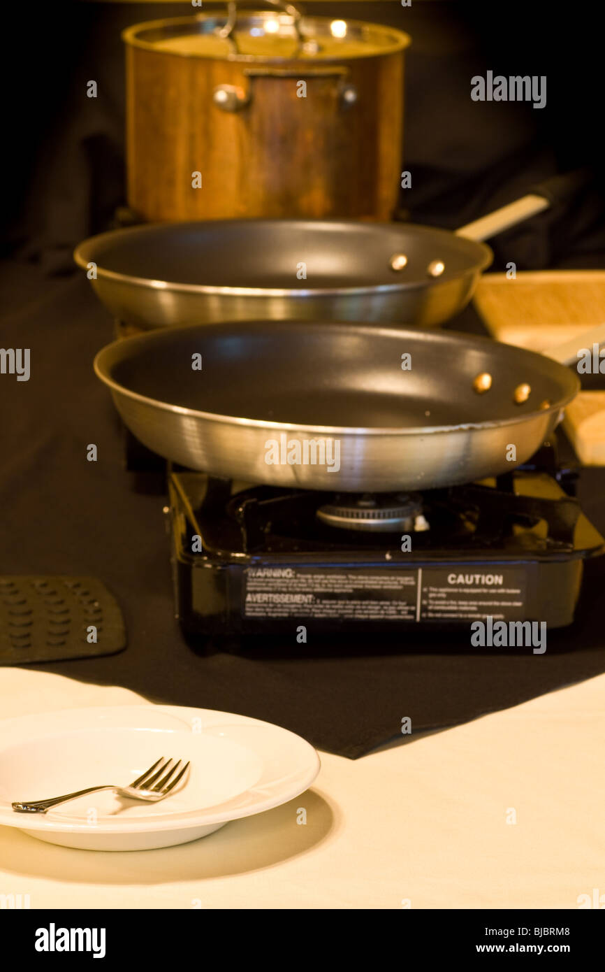 A couple of empty frying pans on a portable stove along a buffet line. Stock Photo