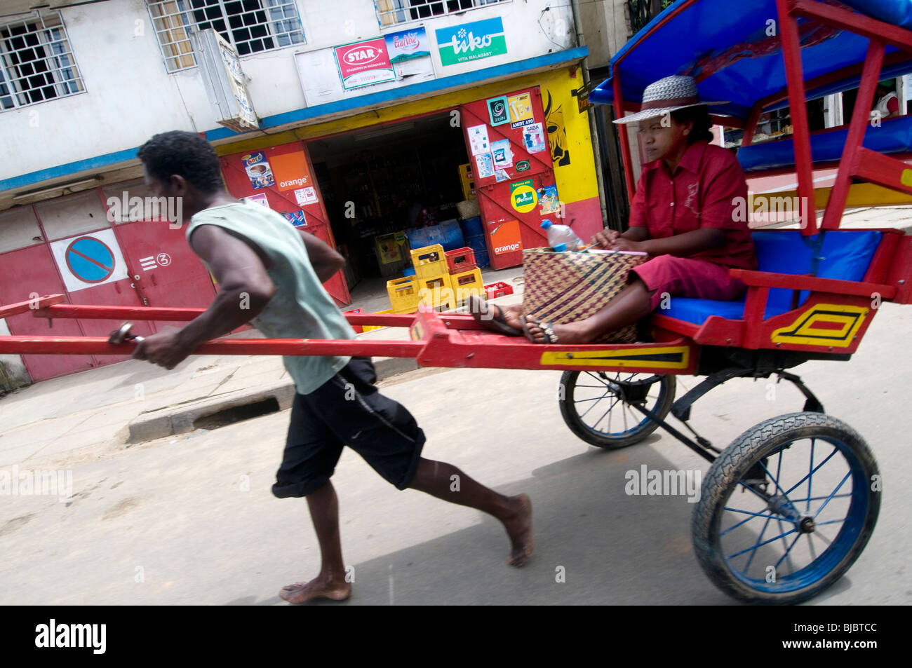 rickshaw puller with woman passenger Stock Photo Alamy