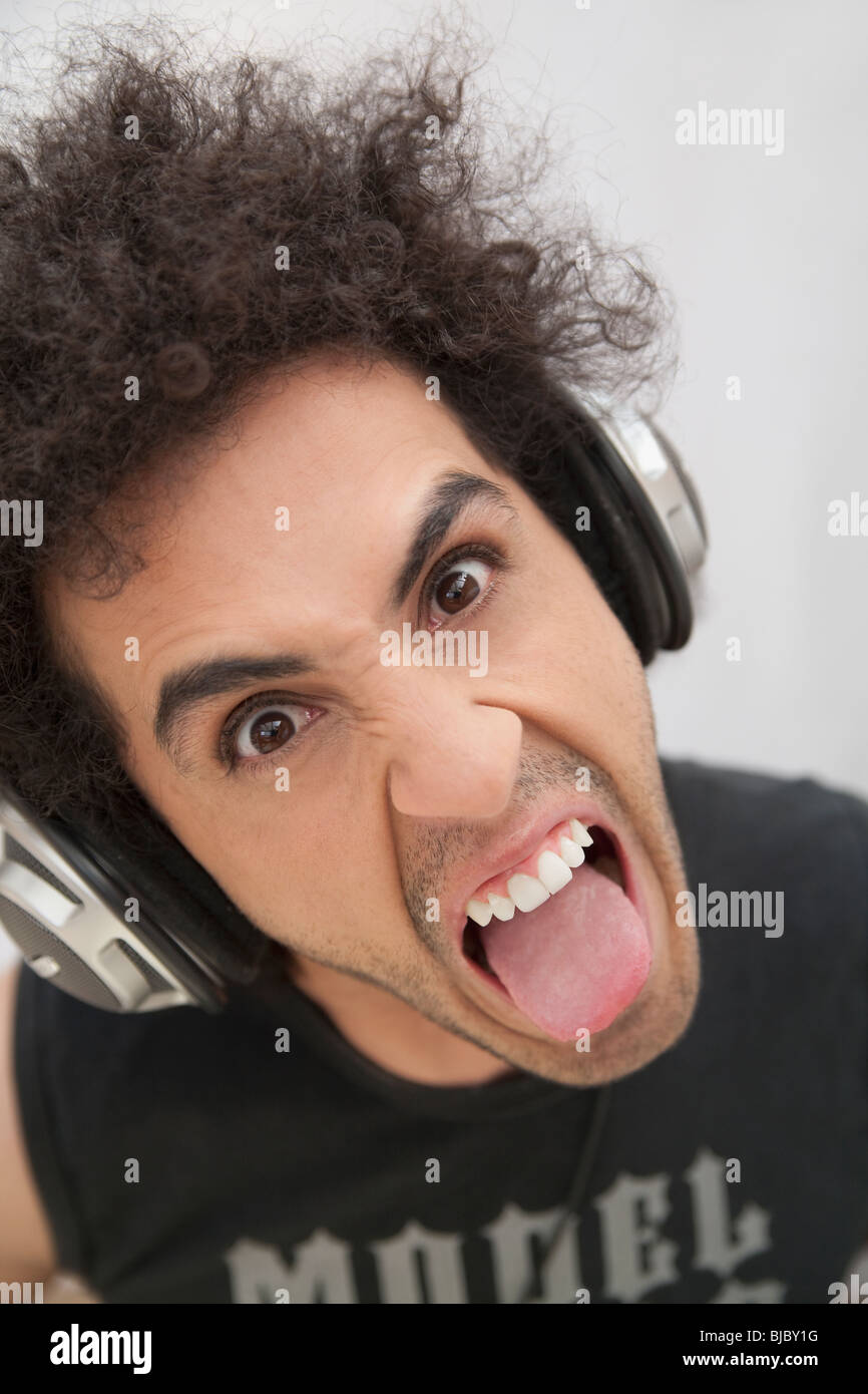 Hispanic man in headphones grimacing Stock Photo