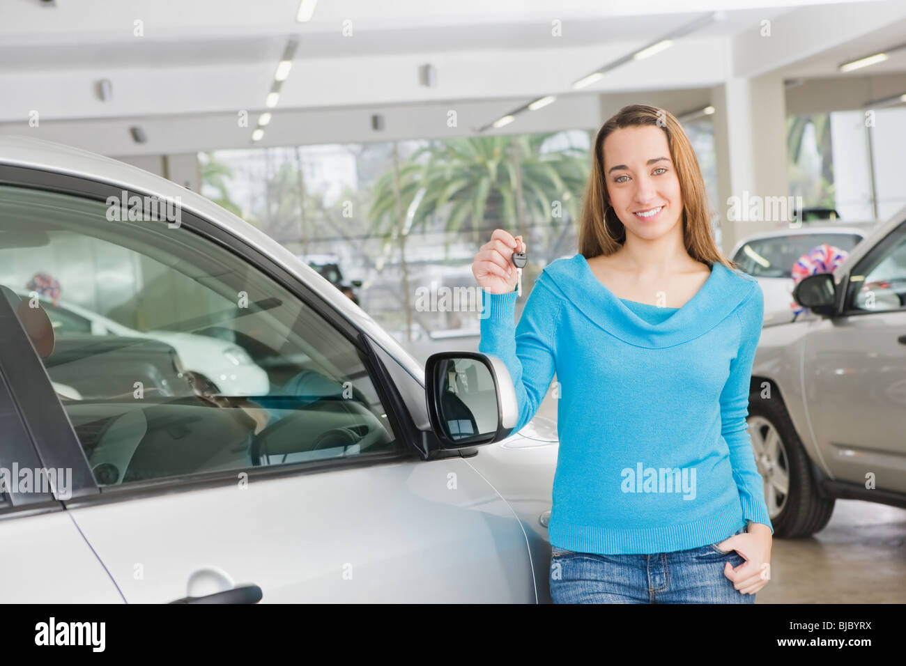 Hispanic woman holding keys to new car Stock Photo