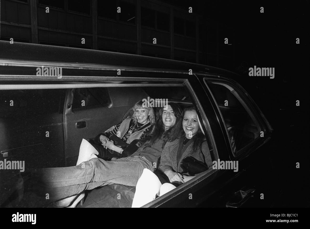 Thin Lizzy on tour in Scandinavia in 1979. Scott Gorham leaves the Copenhagen venue in a limo with some female fans Stock Photo