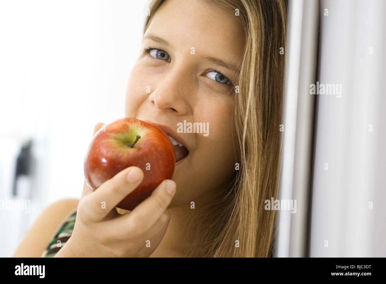 Young woman biting into apple Stock Photo