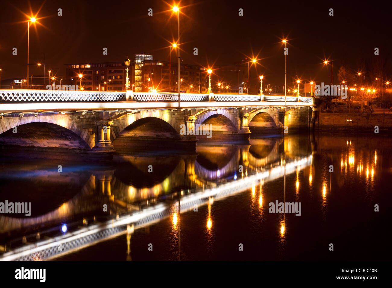 Lights on the Queen's Road Bridge reflected by the water of the River Lagan, Belfast, Northern Ireland Stock Photo