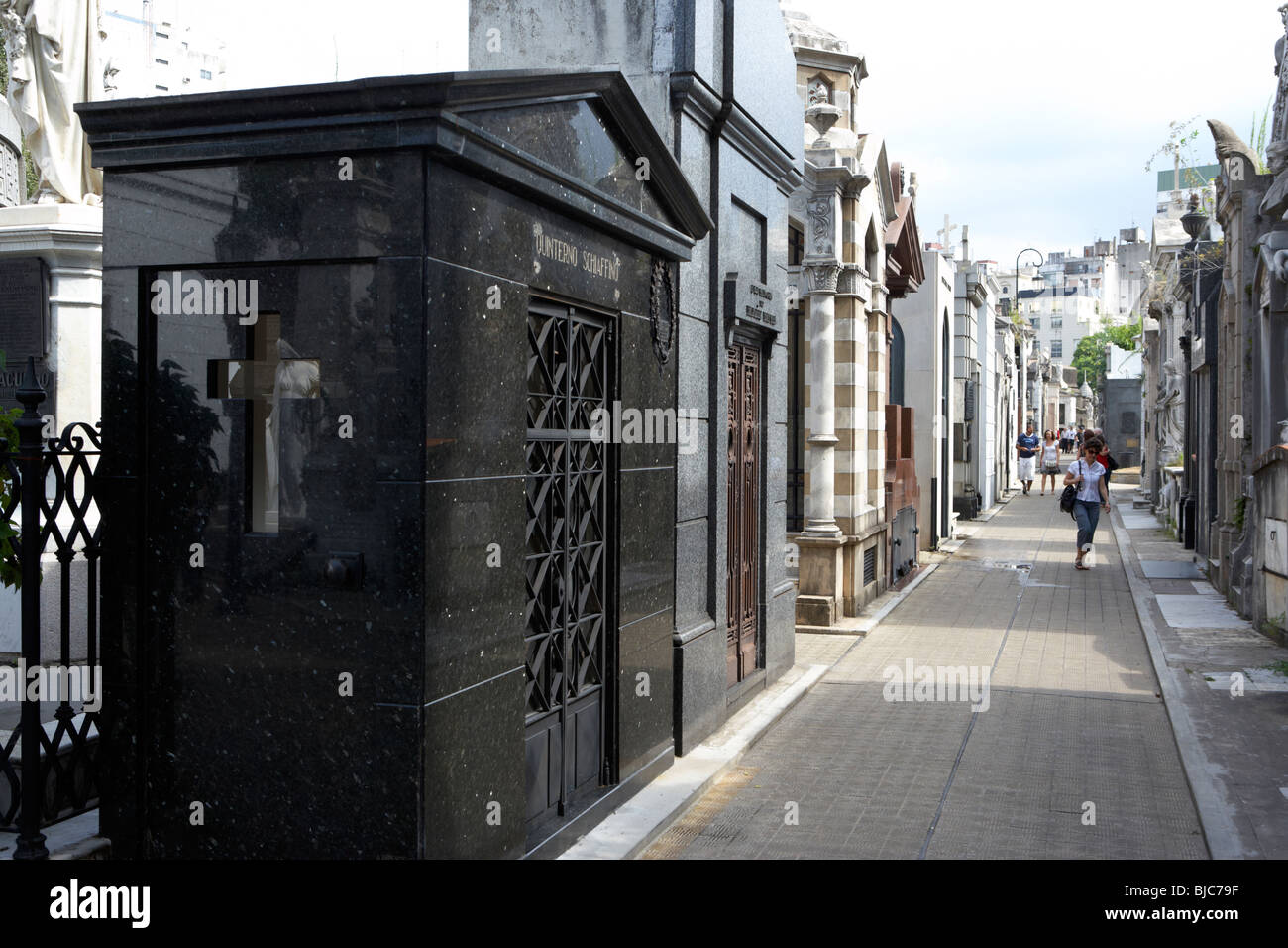 tourists walk row of older mausoleums on a street in recoleta cemetery capital federal buenos aires republic of argentina Stock Photo