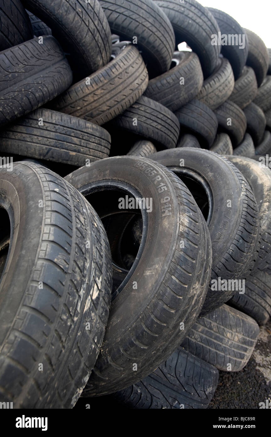 Waste car tyres stacked up in a pile waiting to be recycled Stock Photo