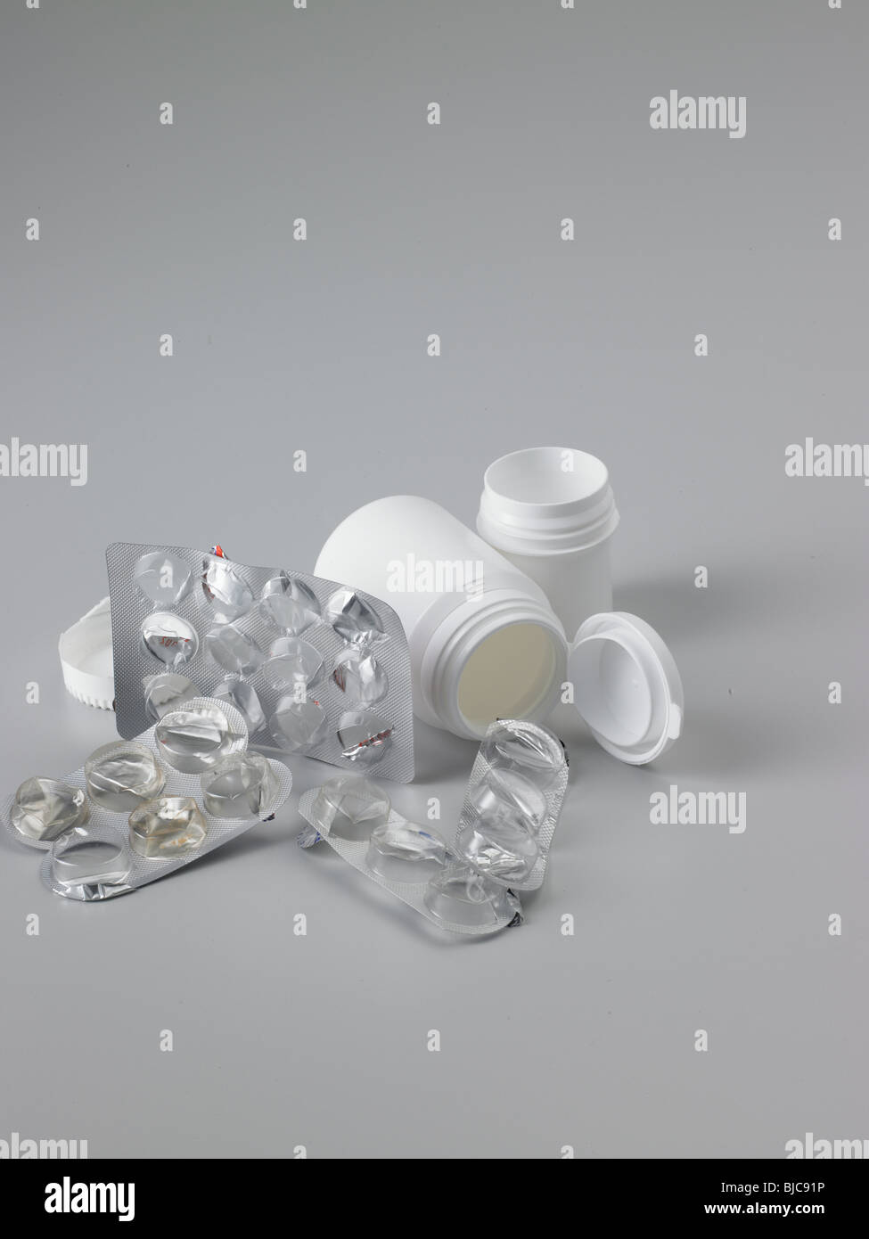 Waste pharmaceutical packaging with white plastic pill bottles shot in portrait format and
