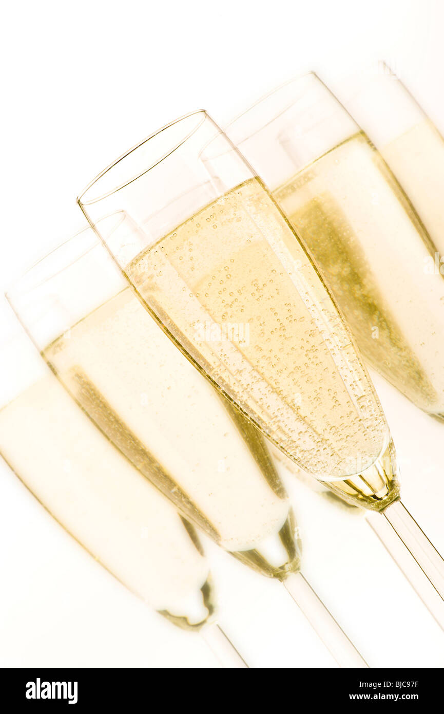 Studio shot of angled flute glasses filled with champagne on white background. Stock Photo