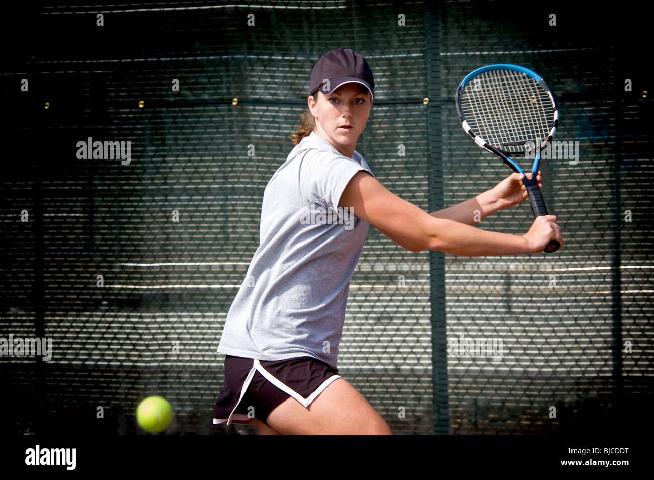 Female college tennis player hitting slice background Stock Photo