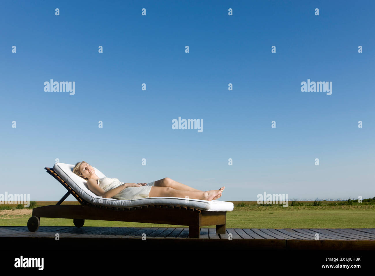 Woman napping on lounge chair on deck Stock Photo Alamy