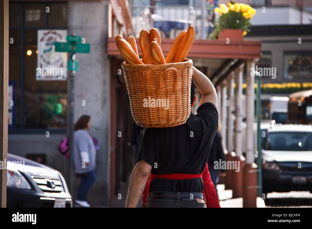 Man carrying basket of fresh French Bread from bakery on street, Pike