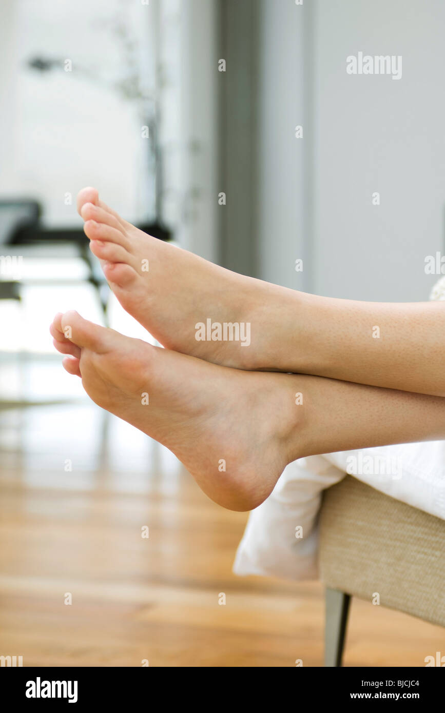 Woman's bare feet, legs crossed at ankle Stock Photo