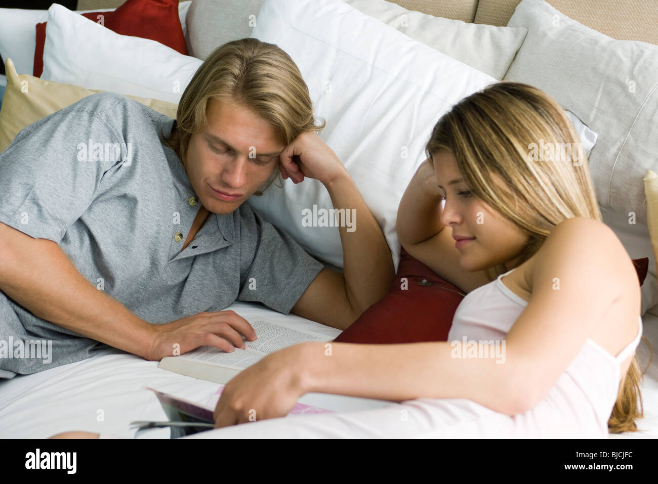 Young couple reading together in bed Stock Photo