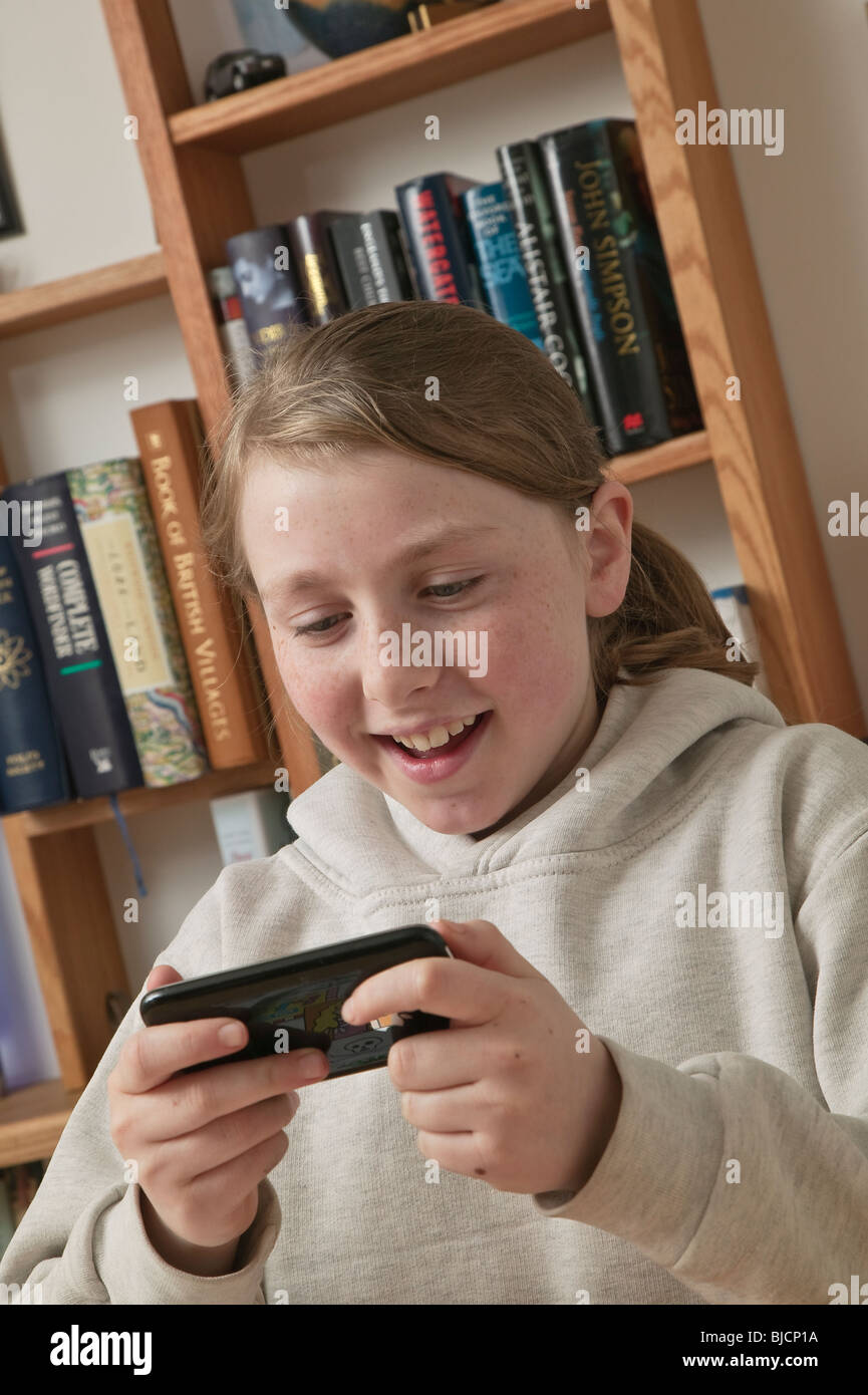 Young girl aged ten playing games on iPhone. Stock Photo