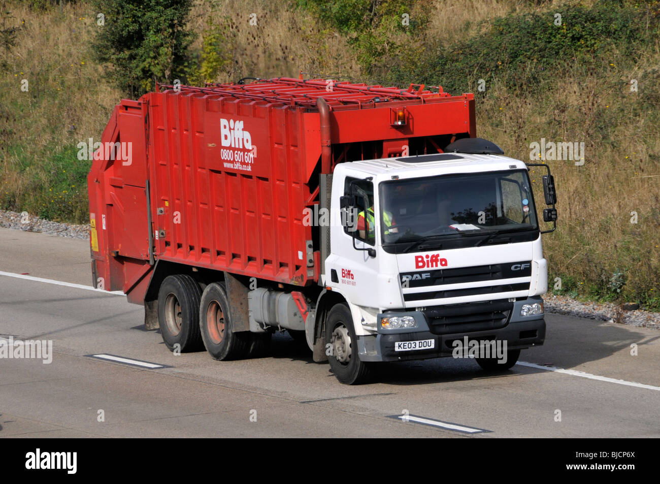 Biffa red dustcart on DAF CF white power unit chassis truck cab semi tractor prime mover lorry a commercial vehicle on M25 motorway Essex England UK Stock Photo