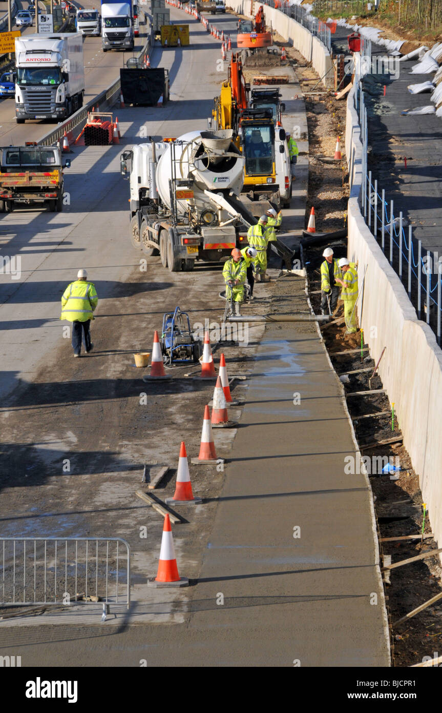 Civil Engineering road works construction workers & machines working busy M25 Motorway site building total four lane road Essex landscape England UK Stock Photo