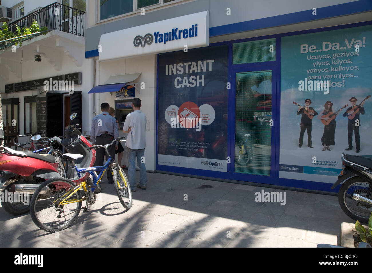 Line Of Customers Waiting To Withdraw Cash From Local Turkish Bank ATM Bodrum Turkey Stock Photo