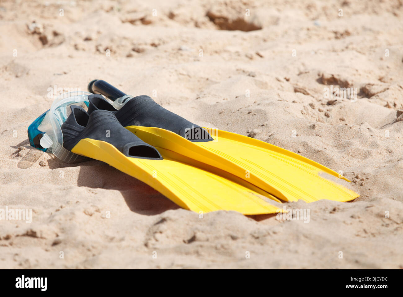 Fins and snorkel mask in beach sand Stock Photo