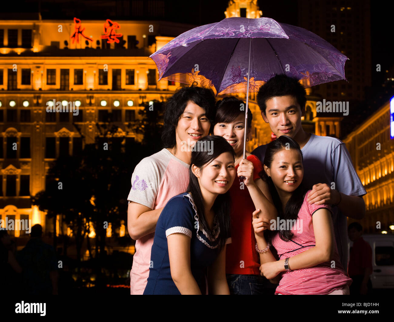 Five young people under an umbrella. Stock Photo