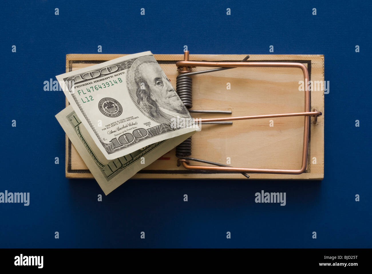 Mouse trap with money as bait. Stock Photo