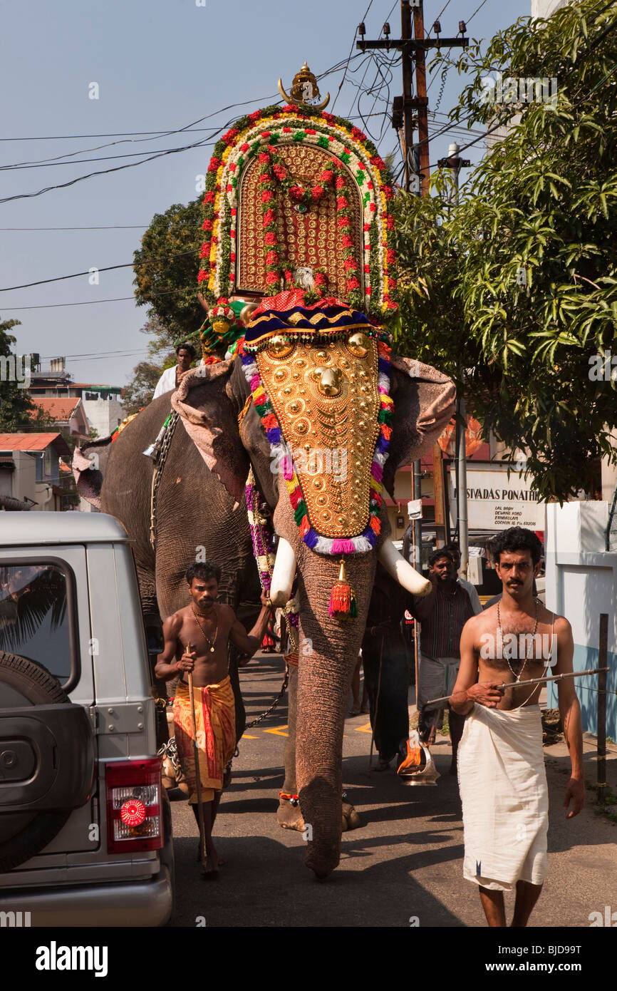 India, Kerala, Kochi, Ernakulam Shiva Temple, Uthsavom festival, caparisoned elephant led by priest through traffic Stock Photo