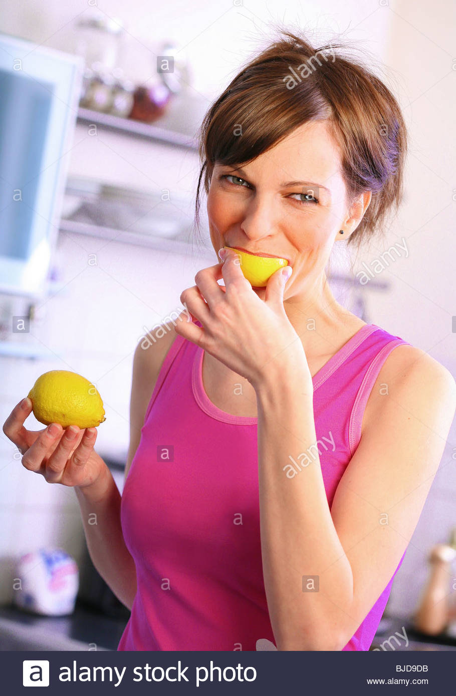 woman biting a lemon Stock Photo