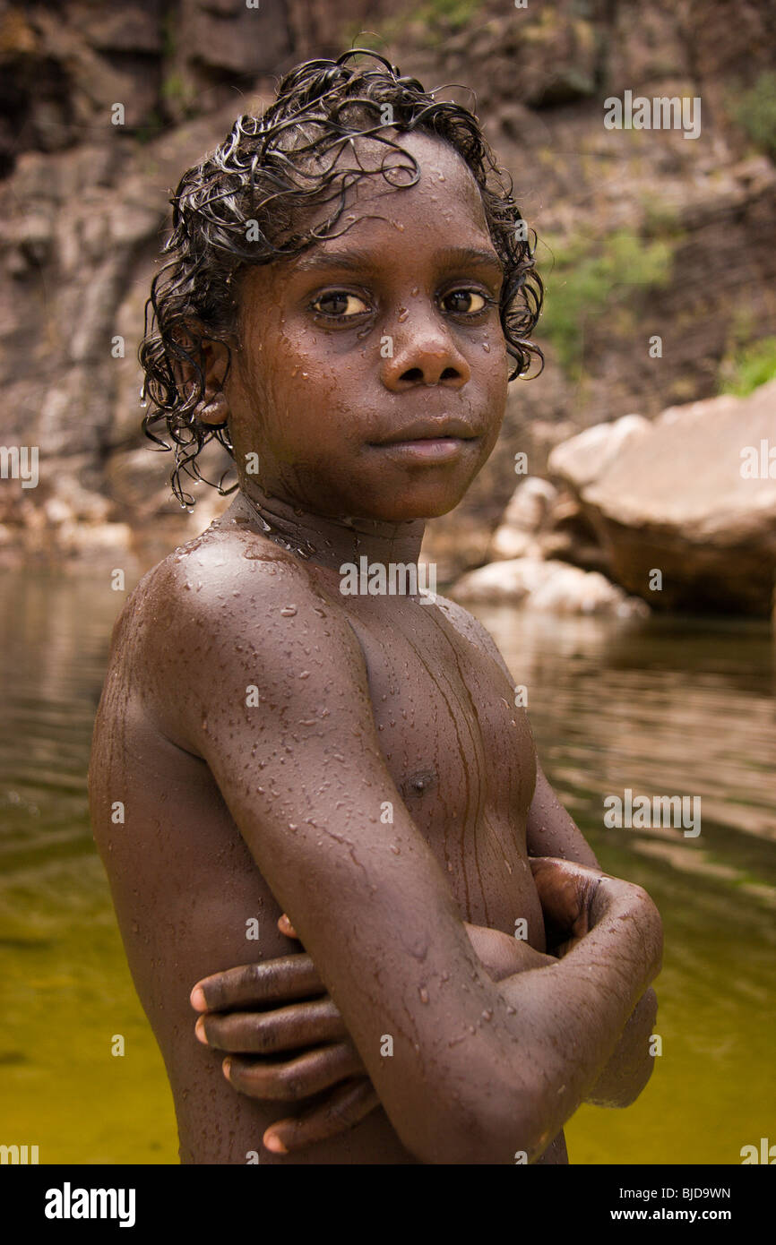 Young Aboriginal boy Micky cools off by the sacred waterhole at Adjumarliari in Eastern Arnhem Land Stock Photo