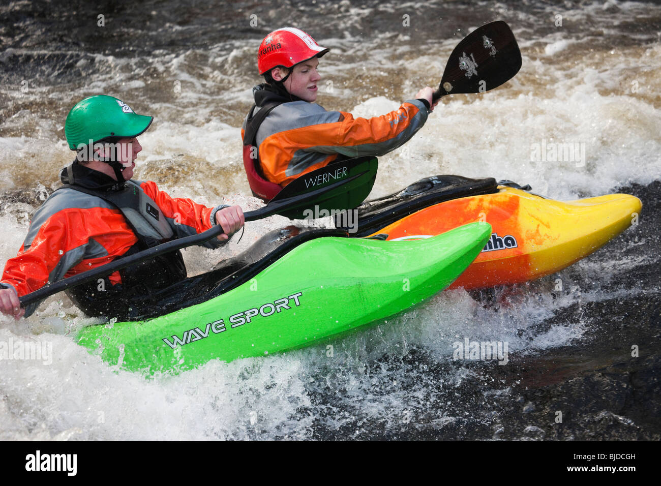 Two kayakers kayaking in white water on Tryweryn River. National