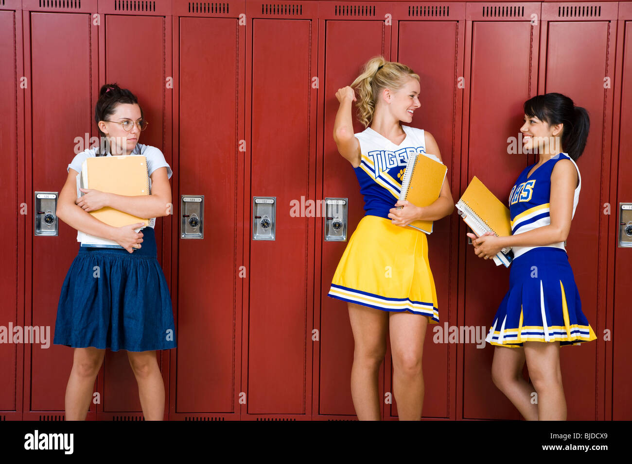 Two High School cheer leaders and a nerd. Stock Photo