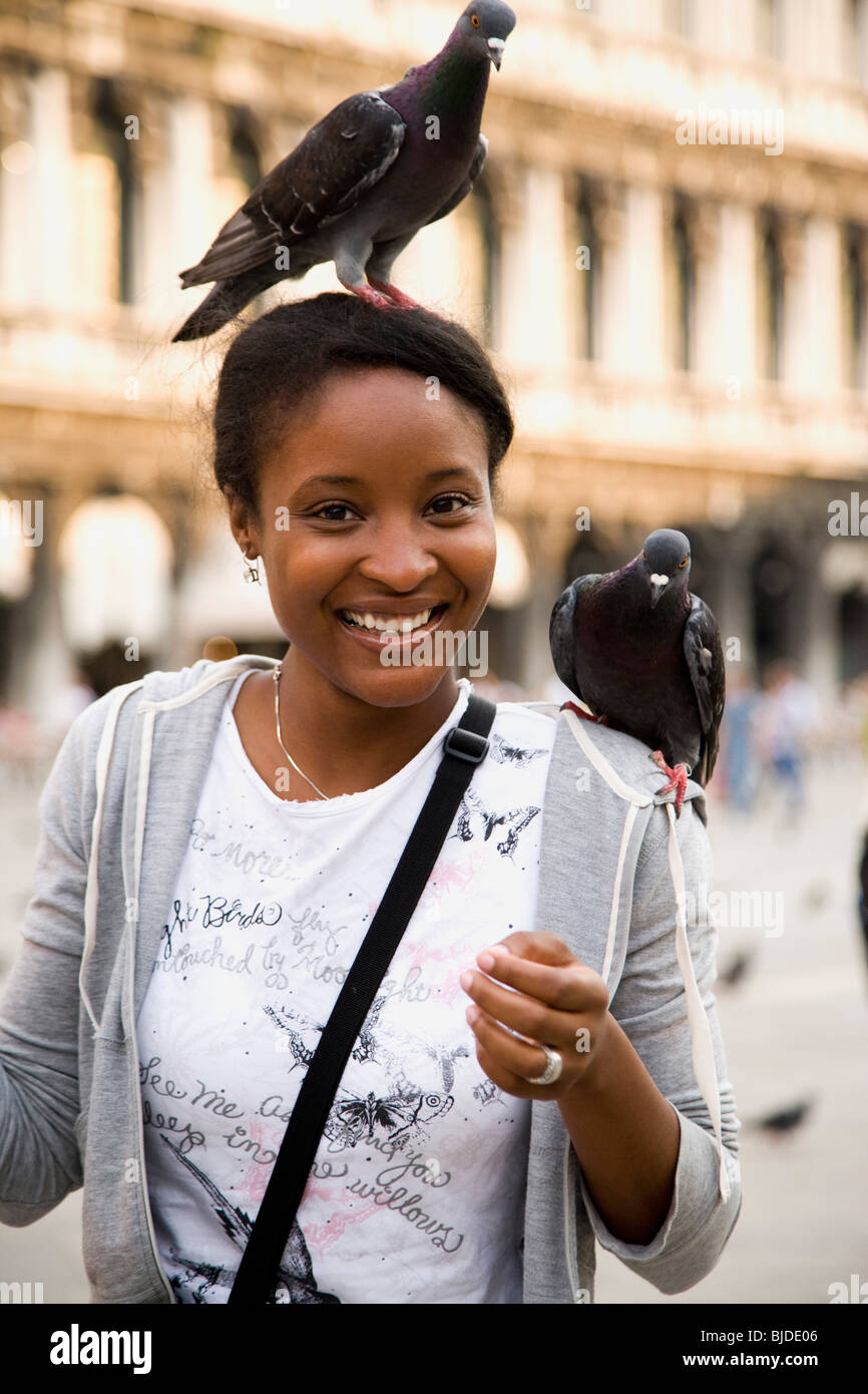 Young woman with birds on her head and shoulder. Stock Photo
