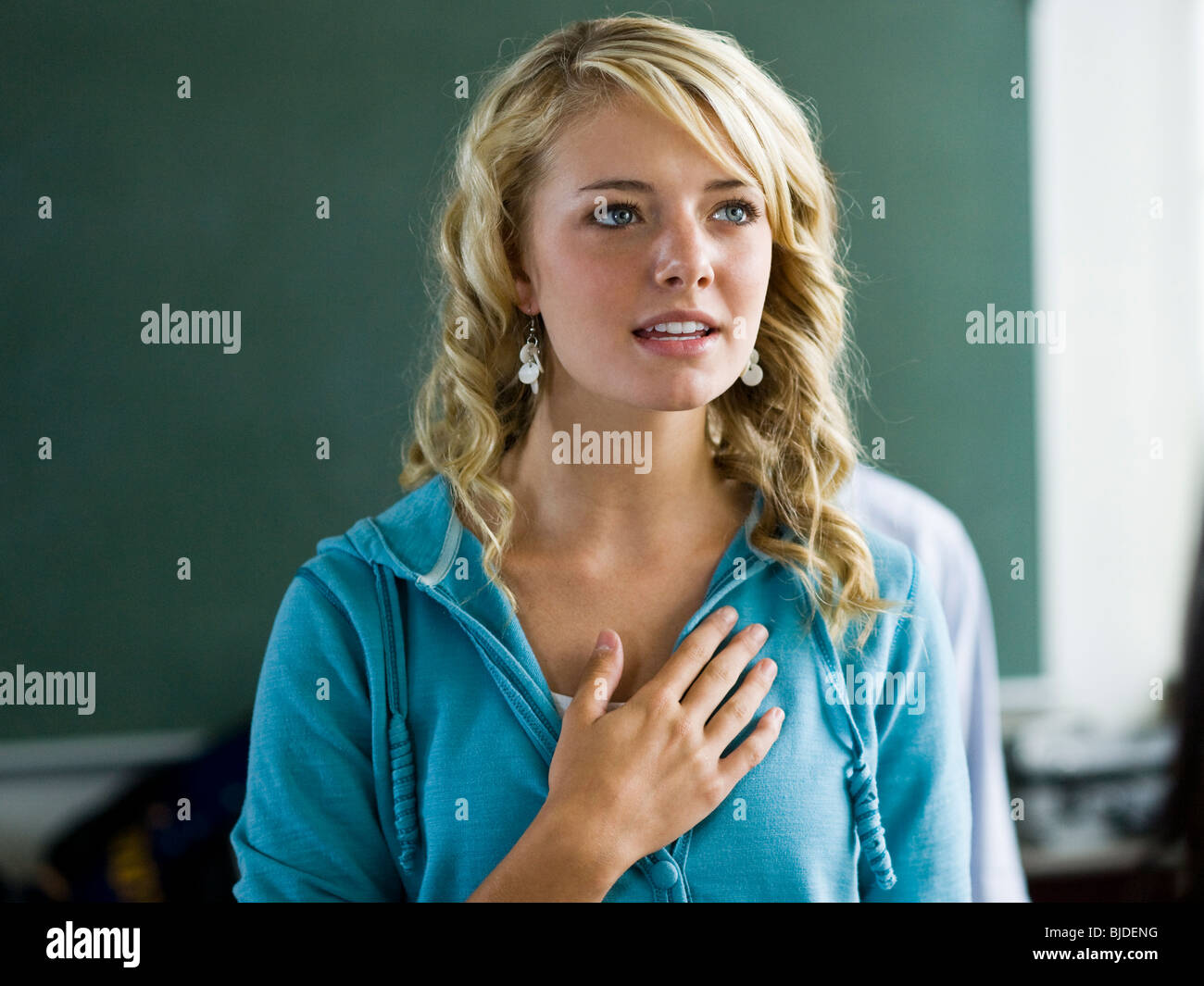 Young woman with hand over heart. Stock Photo