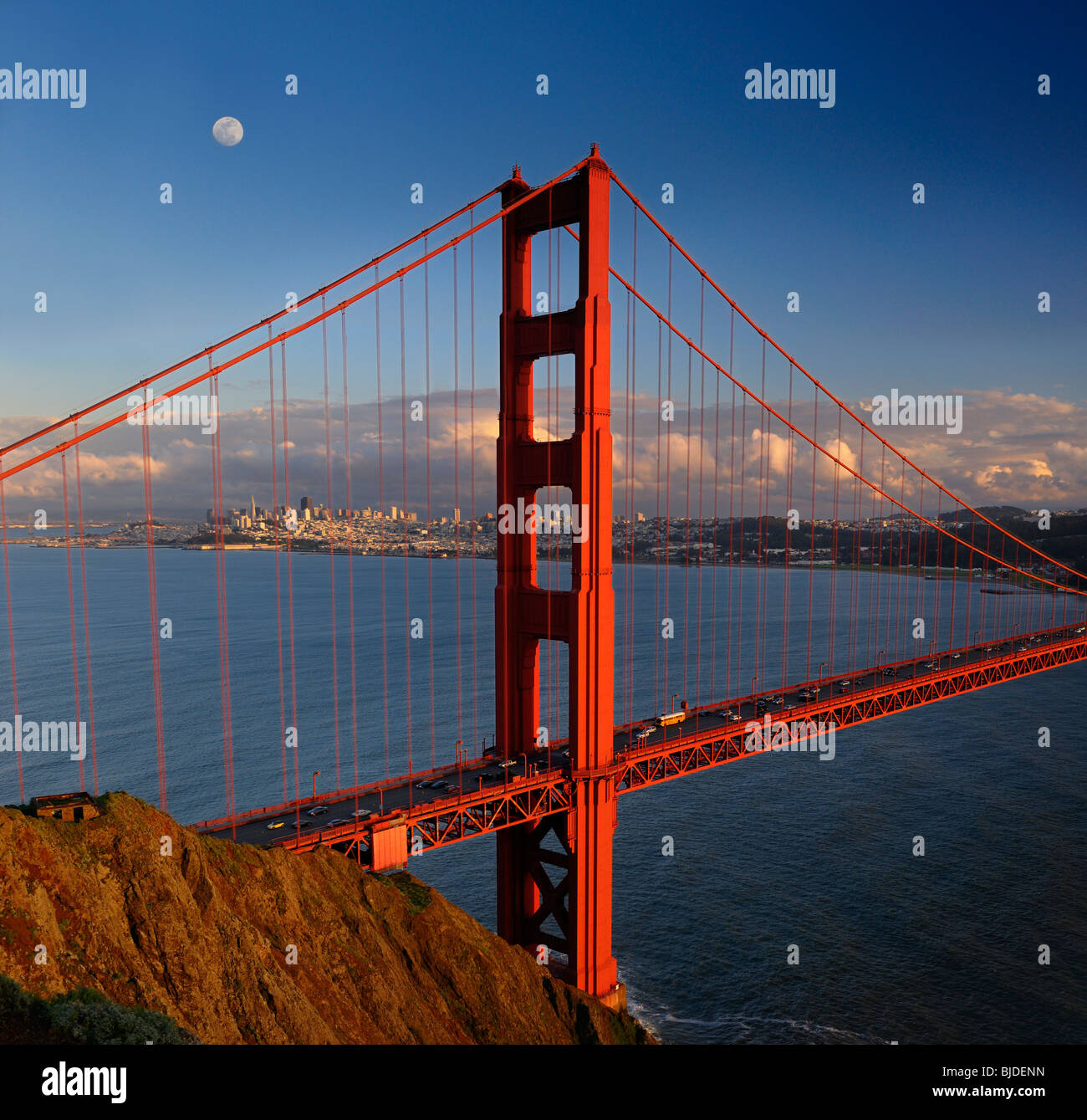 Red Golden Gate Bridge with San Francisco skyline and moon at sunset California USA Stock Photo