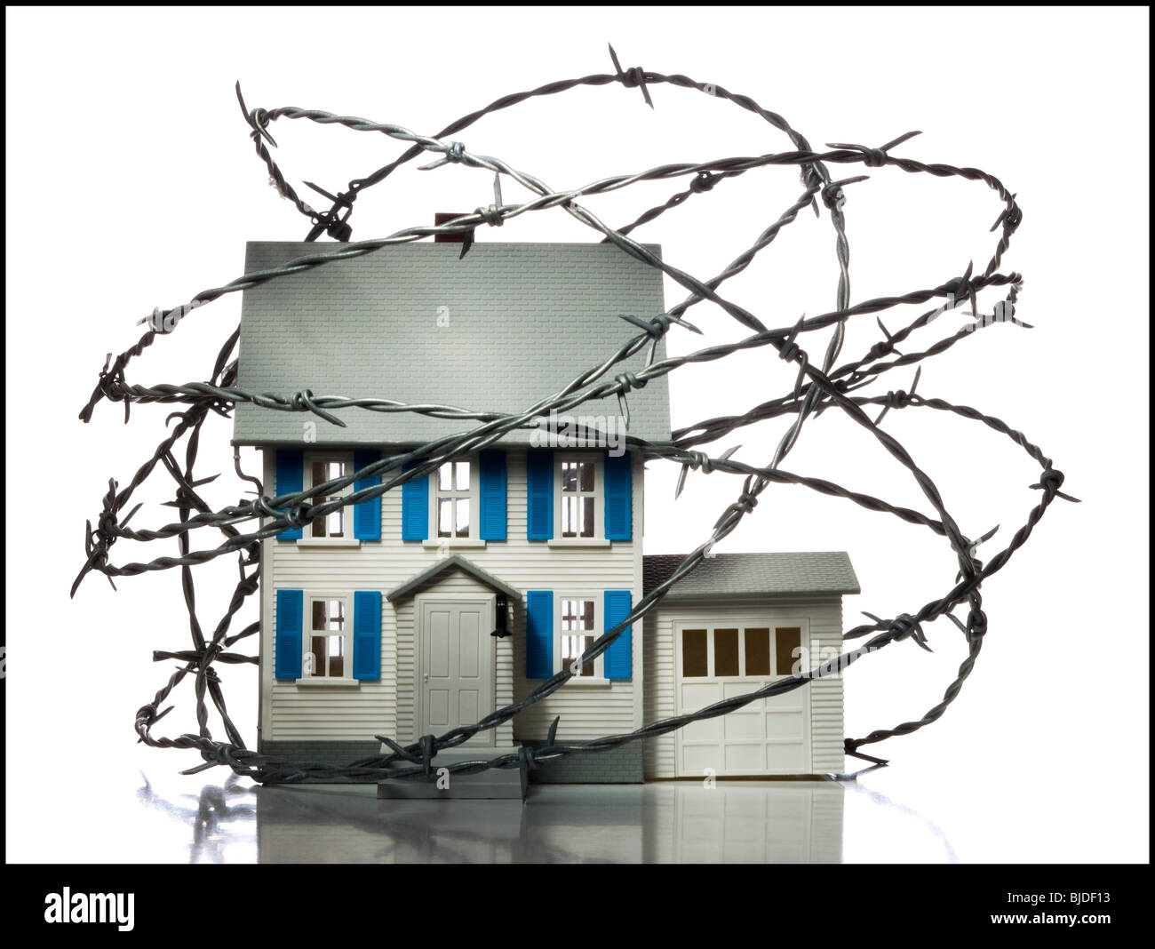 Home surrounded by barbed wire. Stock Photo