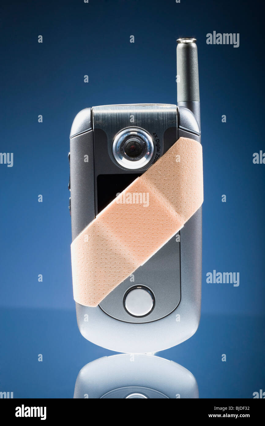 Cell phone with a Band-aid on it. Stock Photo