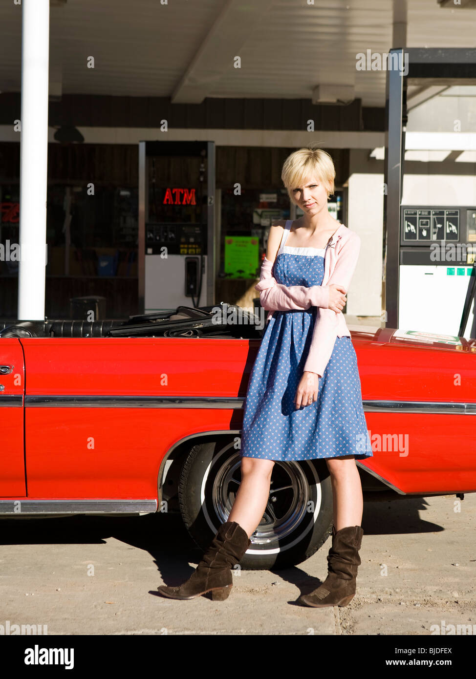 woman with cowboy boots at a gas station. Stock Photo