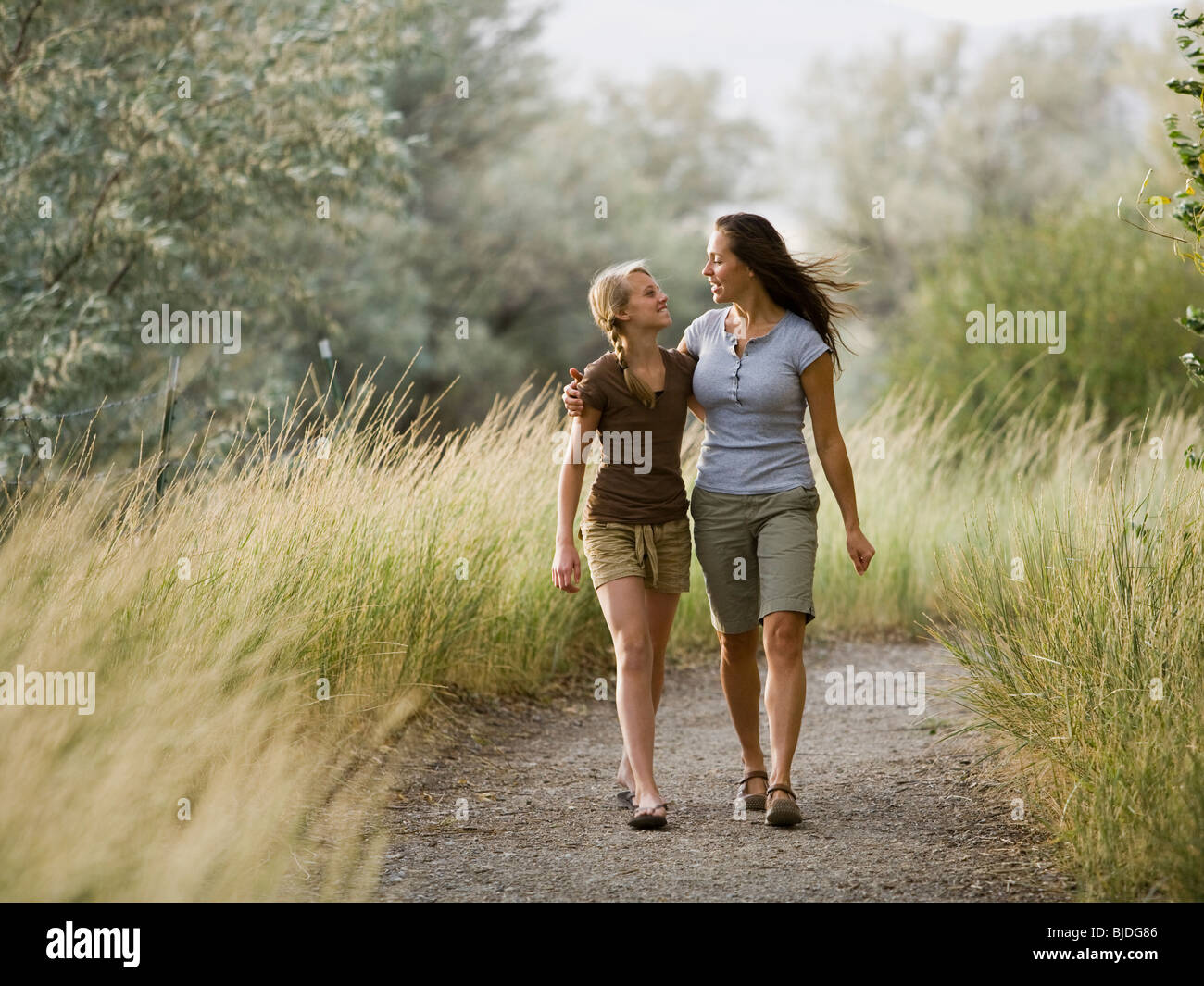 woman and young woman walking with arm around each other. Stock Photo