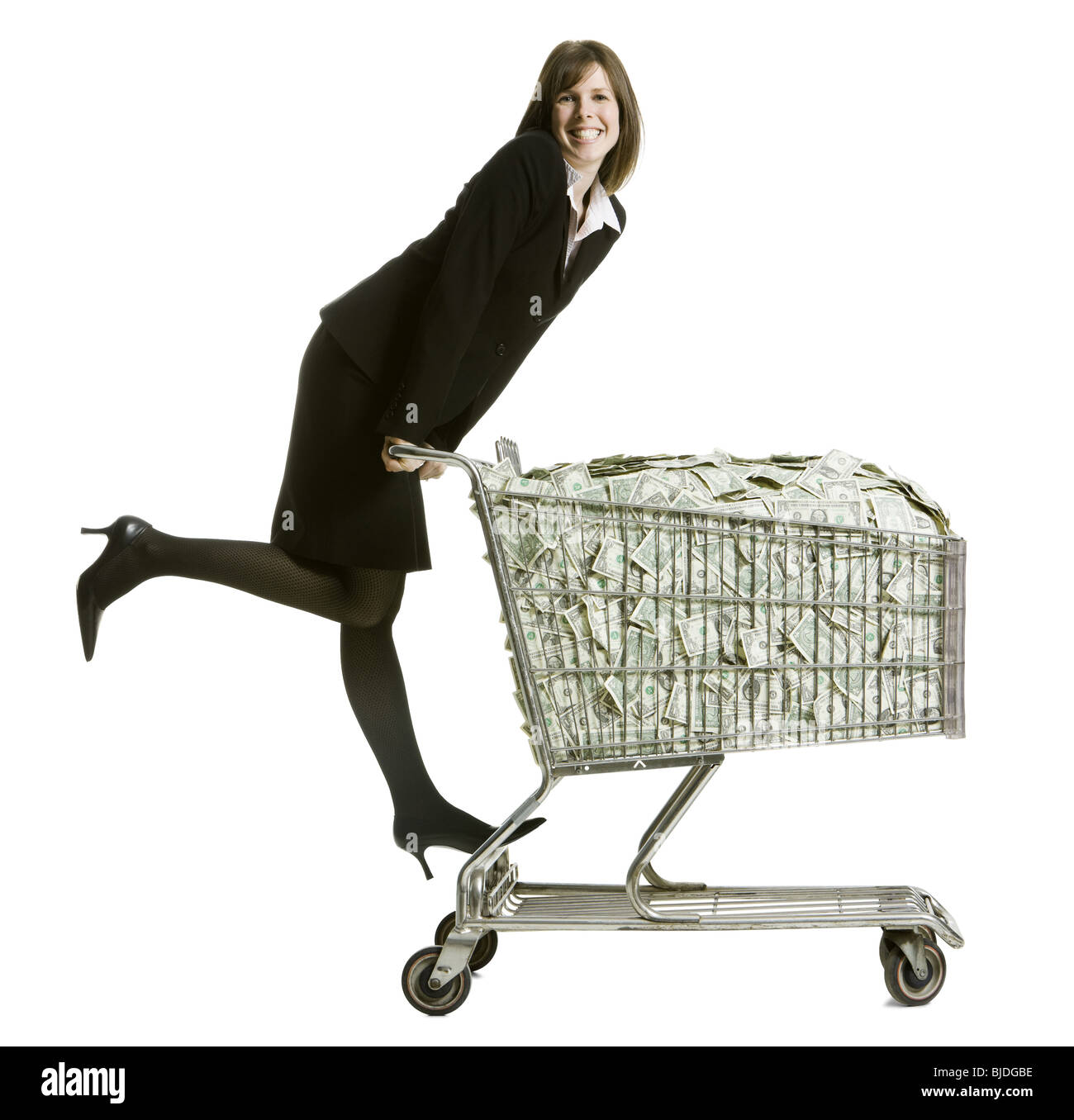 woman with a shopping cart full of money Stock Photo