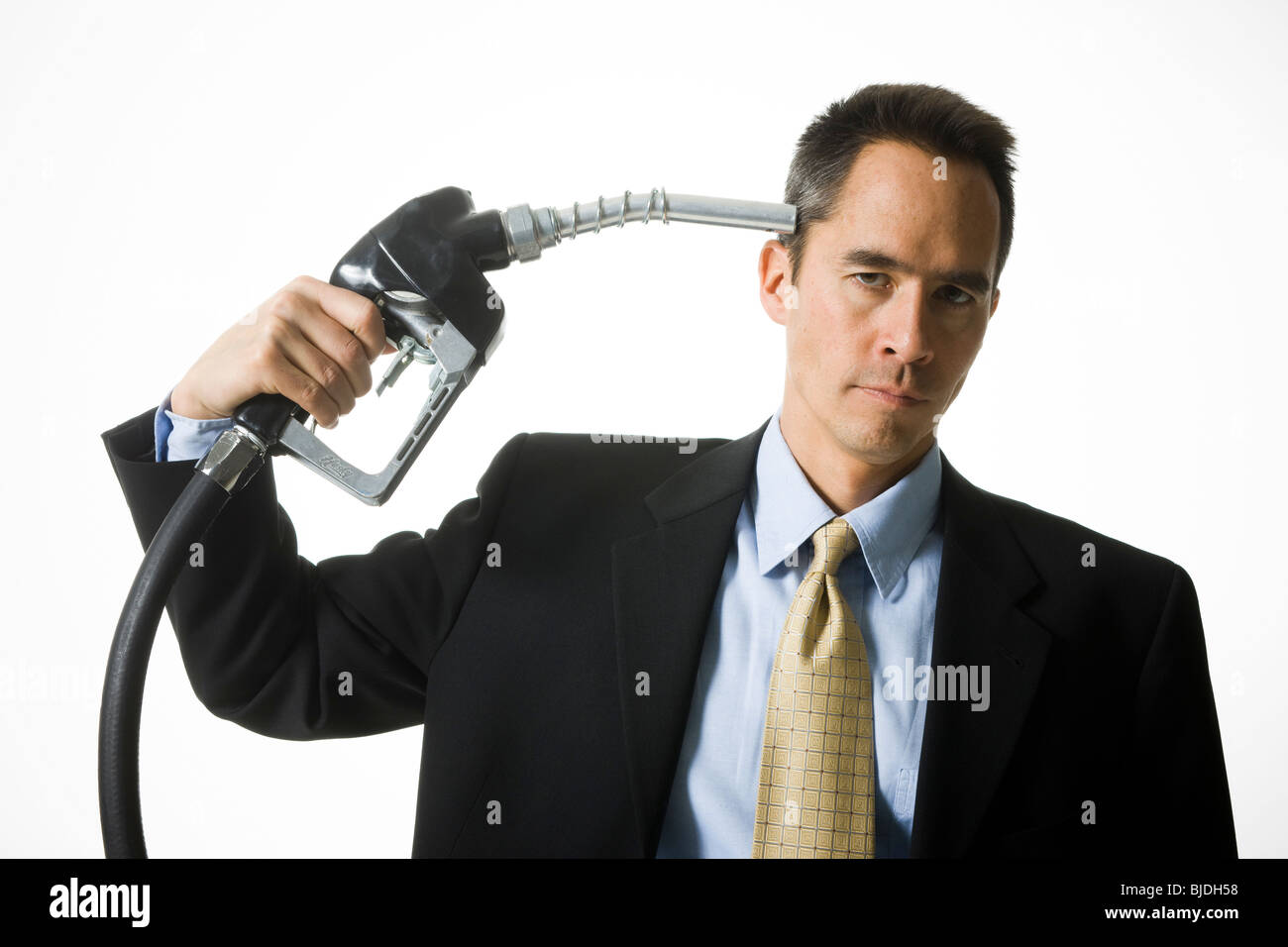 man holding a gas pump to his head Stock Photo
