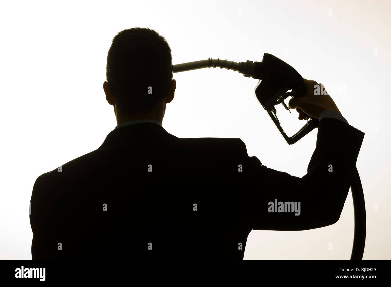 man holding a gas pump to his head Stock Photo