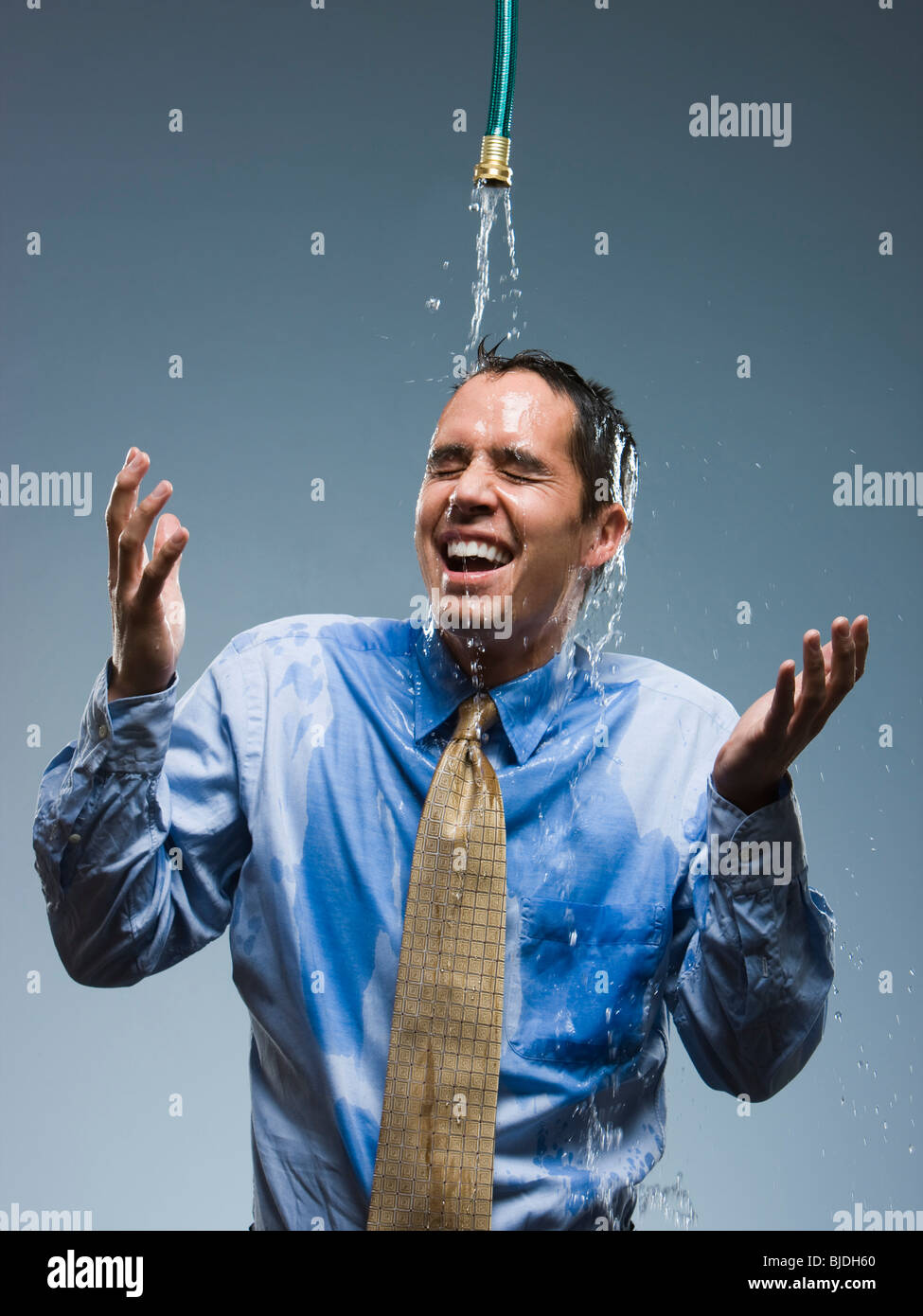 businessman standing under a hose Stock Photo