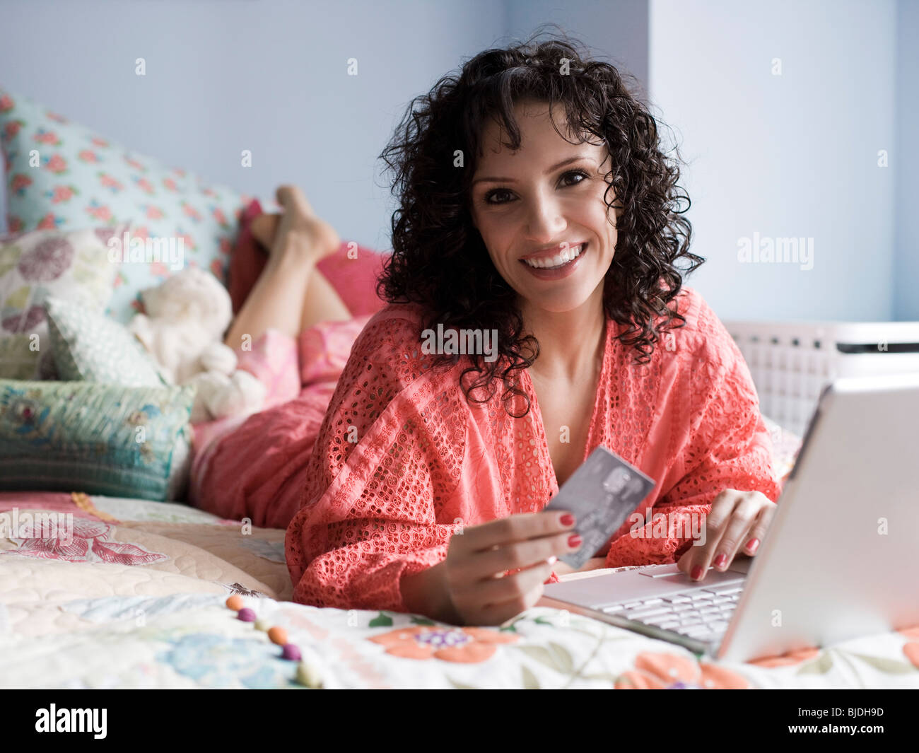 woman lying on a bed with a notebook computer Stock Photo - Alamy