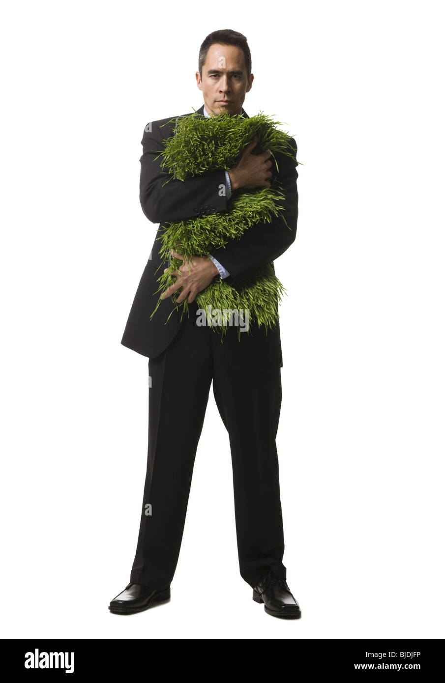 businessperson holding a patch of grass Stock Photo