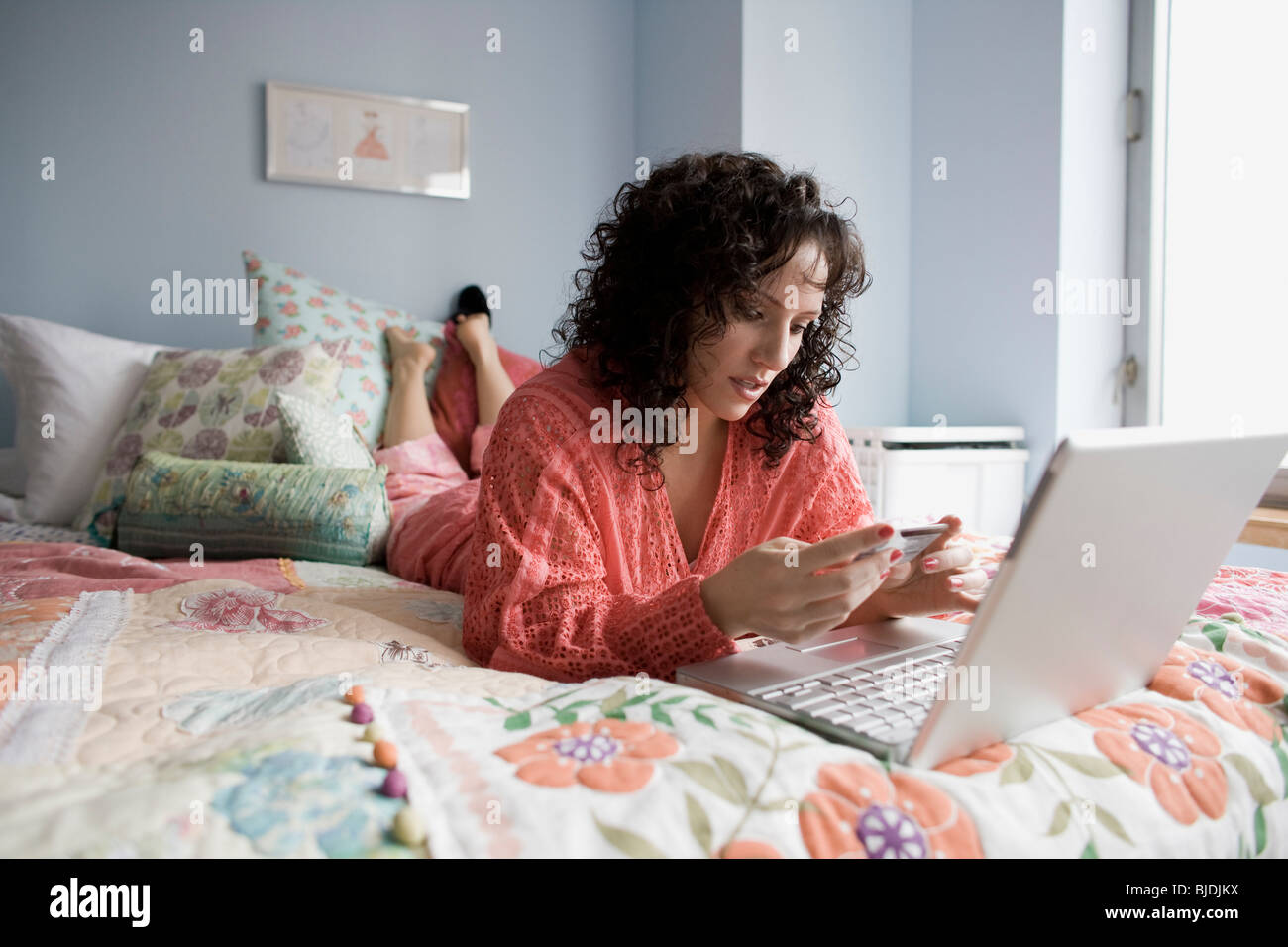 woman lying on a bed with a notebook computer Stock Photo - Alamy