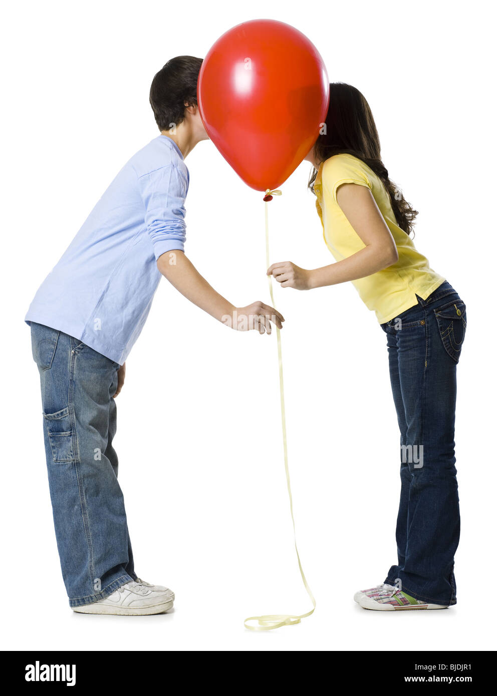 couple kissing behind a red balloon Stock Photo
