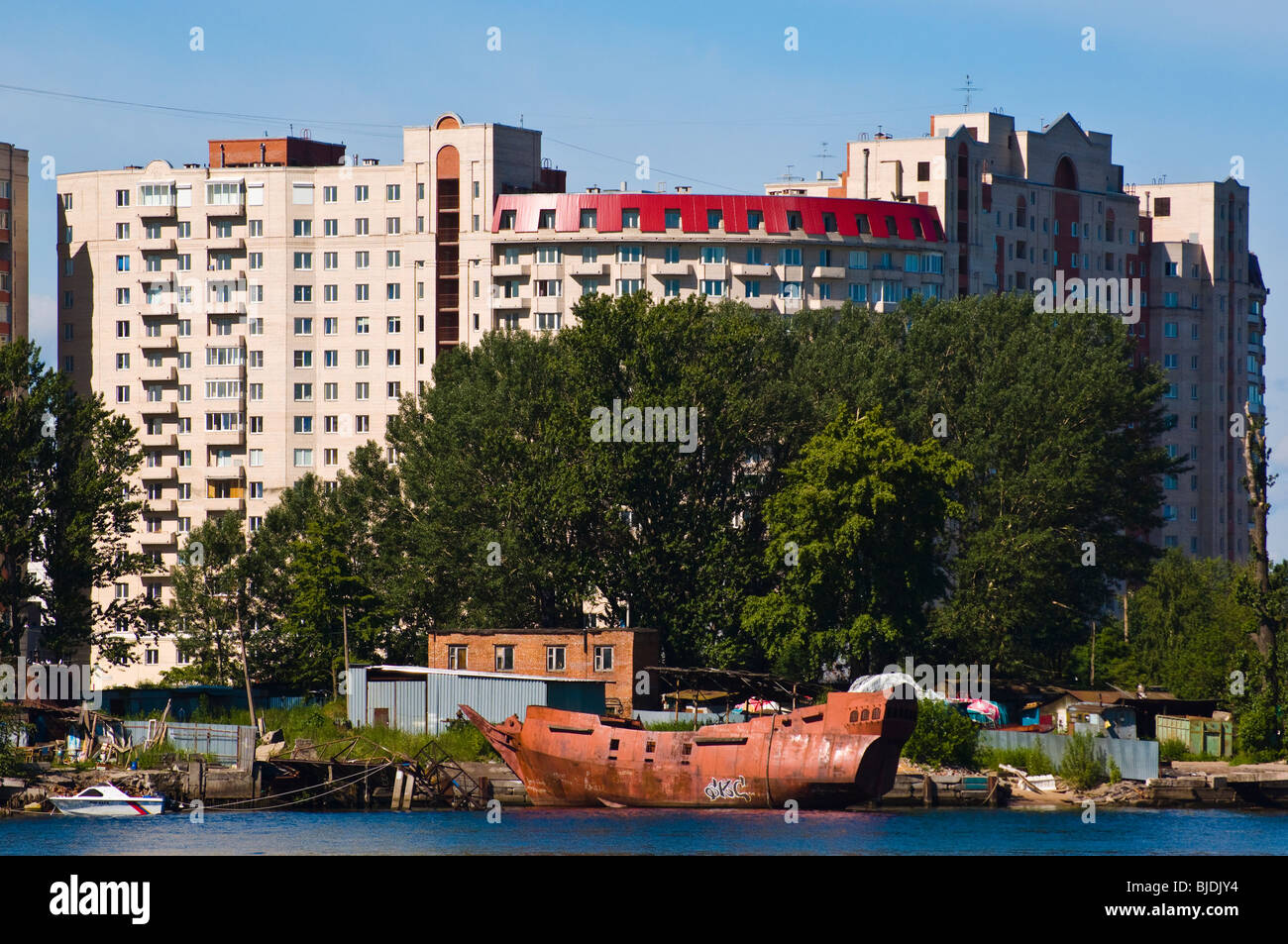 Boatyard and hull of a replica galleon in front of massive apartment block near mouth of River Neva, St Petersburg, Russia Stock Photo