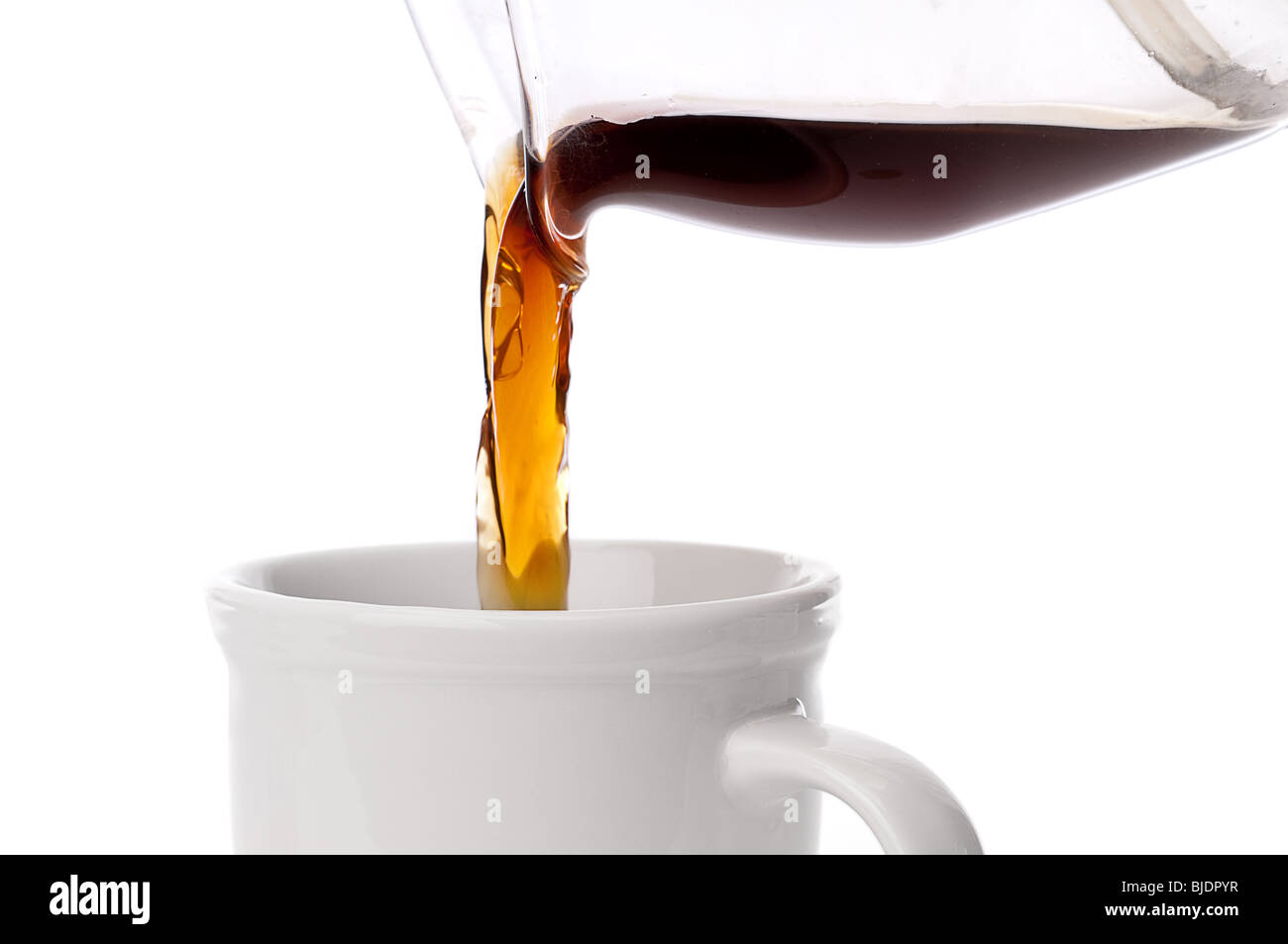 close up of coffee being poured into a coffee cup on white Stock Photo