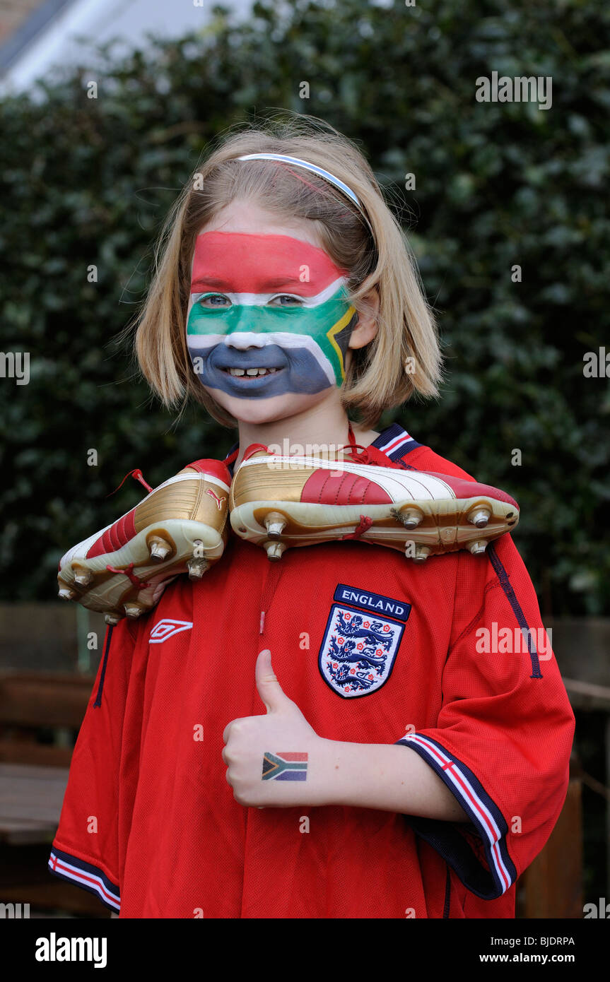 Young football supporter girl wearing red England shirt with face painted in colours of the national flag of South Africa Stock Photo