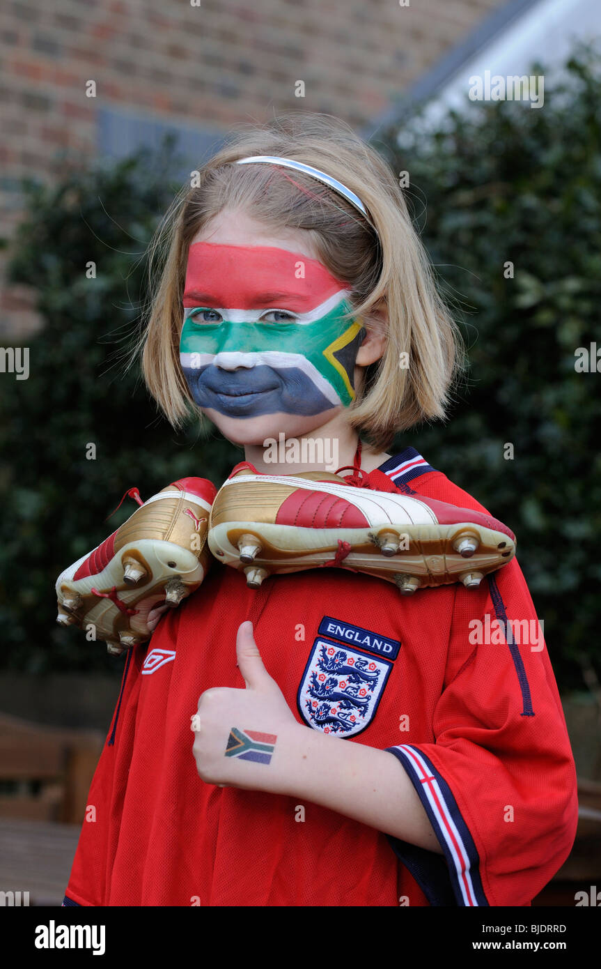 Young football supporter girl wearing red England shirt with face painted in colours of the national flag of South Africa Stock Photo
