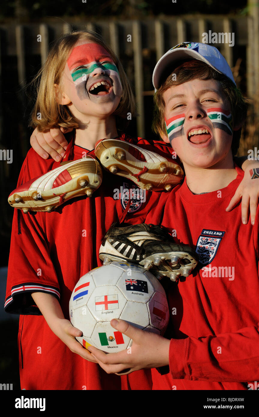 Young football supporters boy & girl wearing red England shirts with face painted faces in colours of  South Africa flag Stock Photo